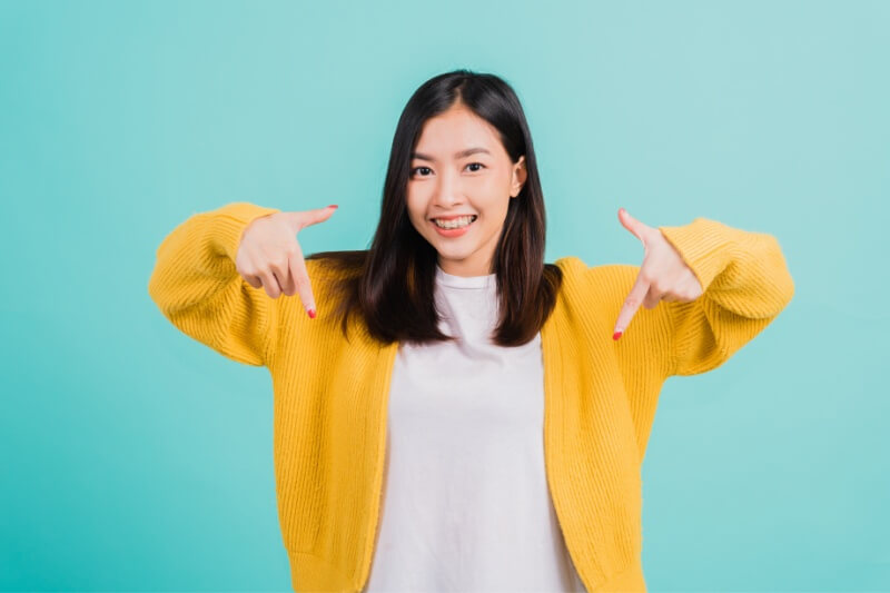 woman in yellow showing thumbs down