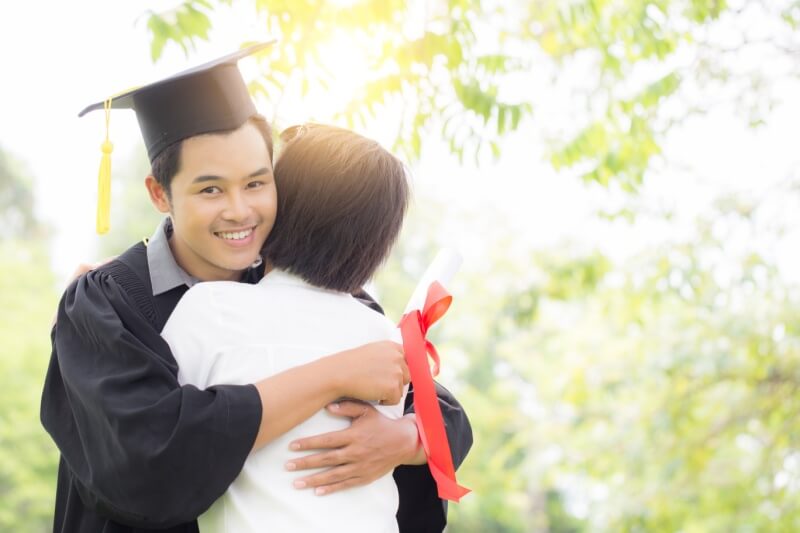 son hugging mother during graduation