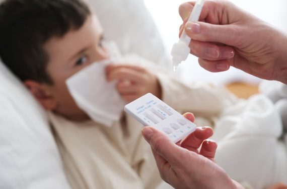 young boy sick with flu test kit