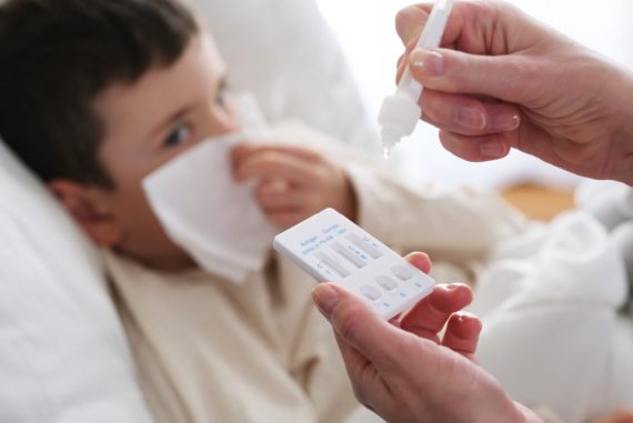 young boy sick with flu test kit