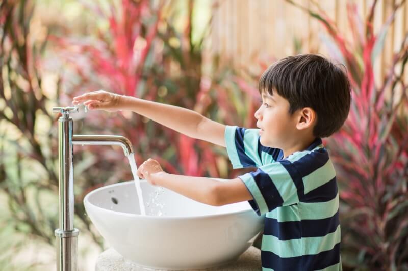 boy washing hands on sink