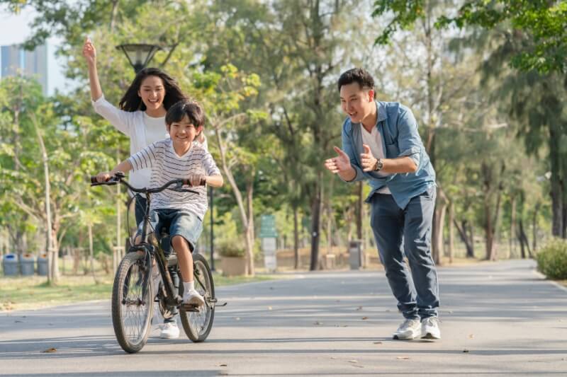 parents with child riding bicycle