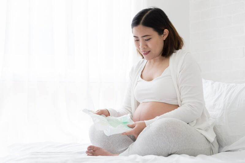 pregnant mummy looking at diapers for baby