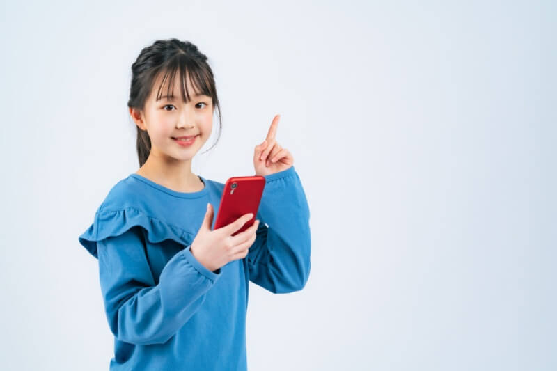 young girl in blue shirt with phone