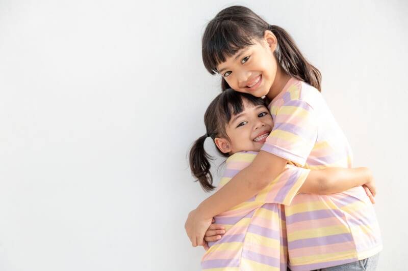 sisters in matching clothes hugging each other