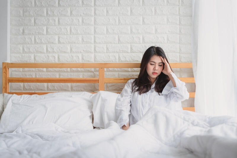 pregnant woman on the bed with headache