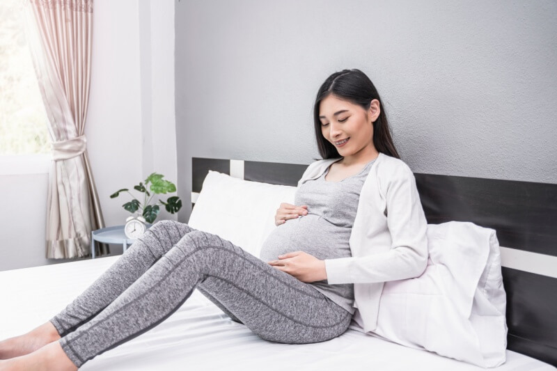 pregnant woman resting on the bed