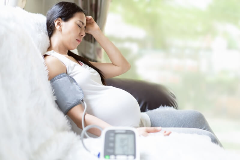 pregnant woman using high blood pressure machine