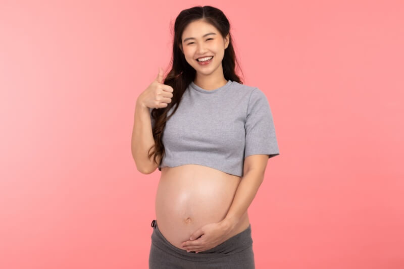 pregnant woman showing thumbs up