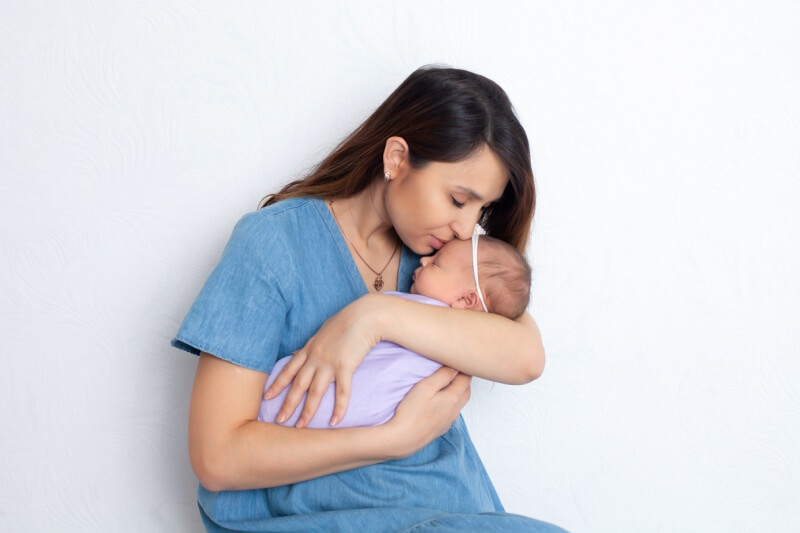 mother kissing babies forehead