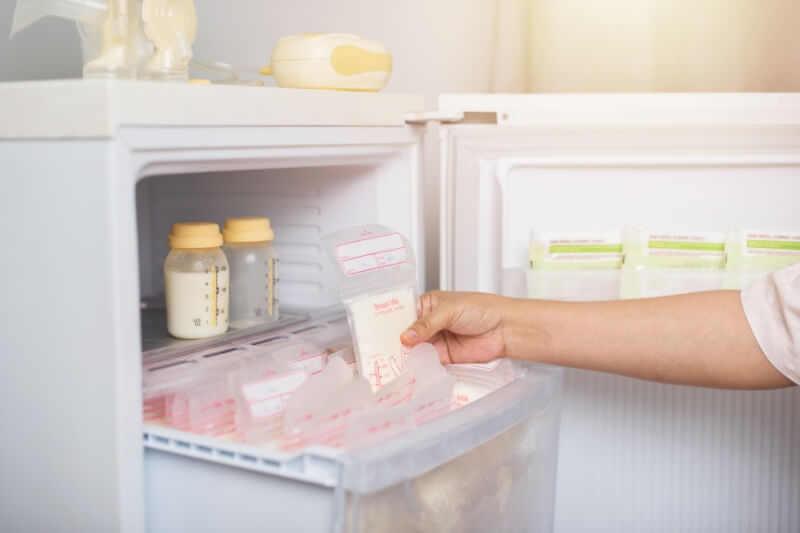 pumped breastmilk being put into the freezer