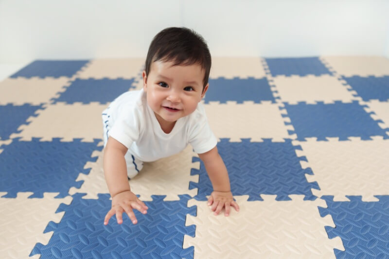 baby crawling on playmat