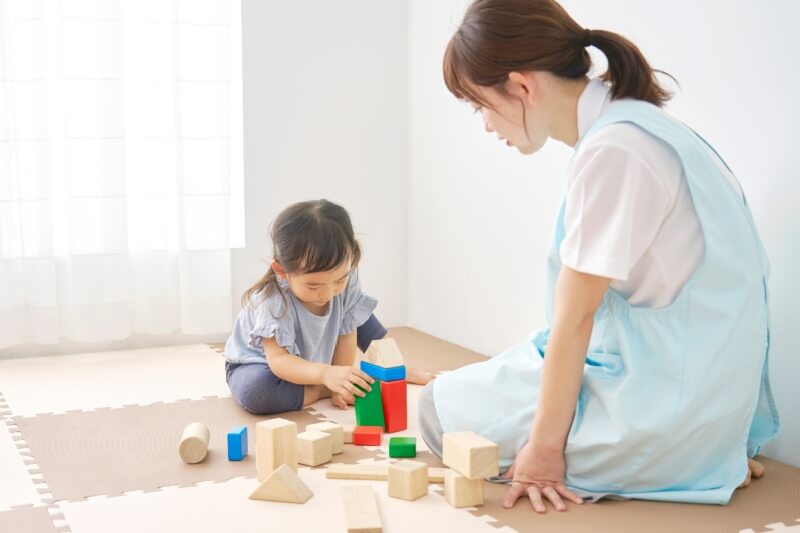 nanny playing with baby on playmat