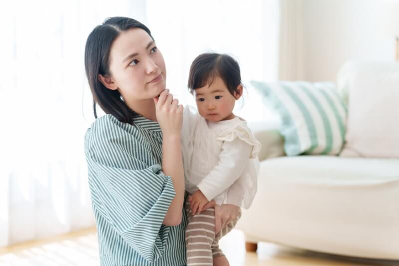 mother carrying baby while thinking