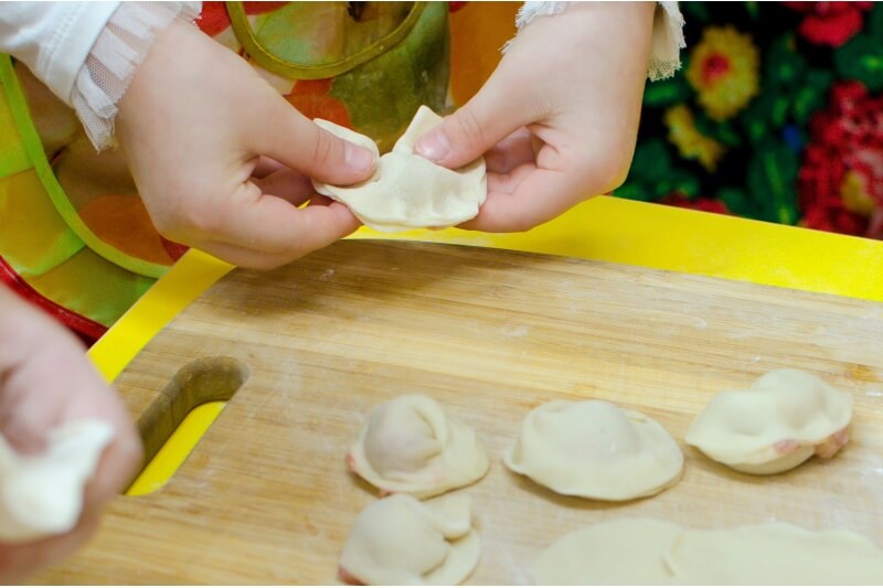 Children's hands make dumplings.