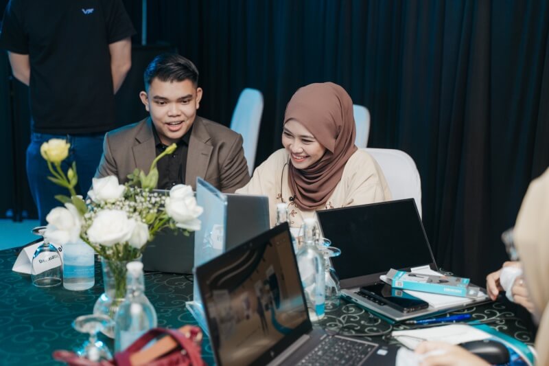 two participants using laptop at event