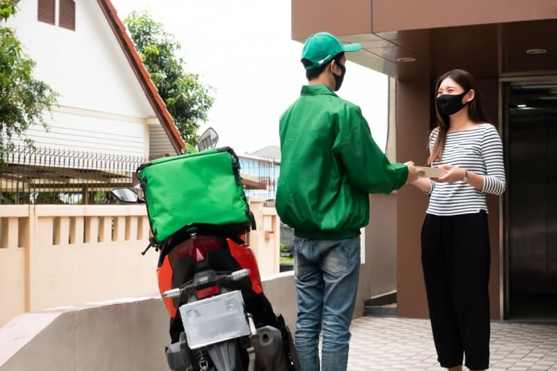 food delivery man with woman receiving food