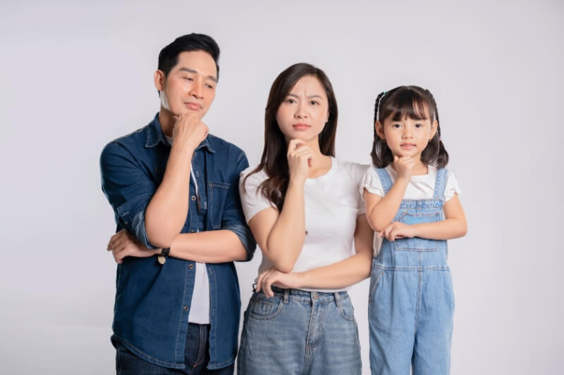 young family with daughter with hands on chin wondering