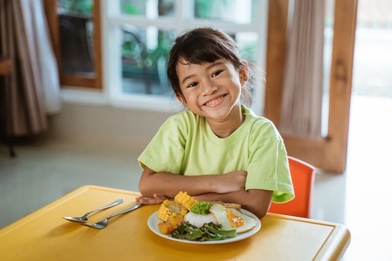 little girl on dining table waiting for iftar