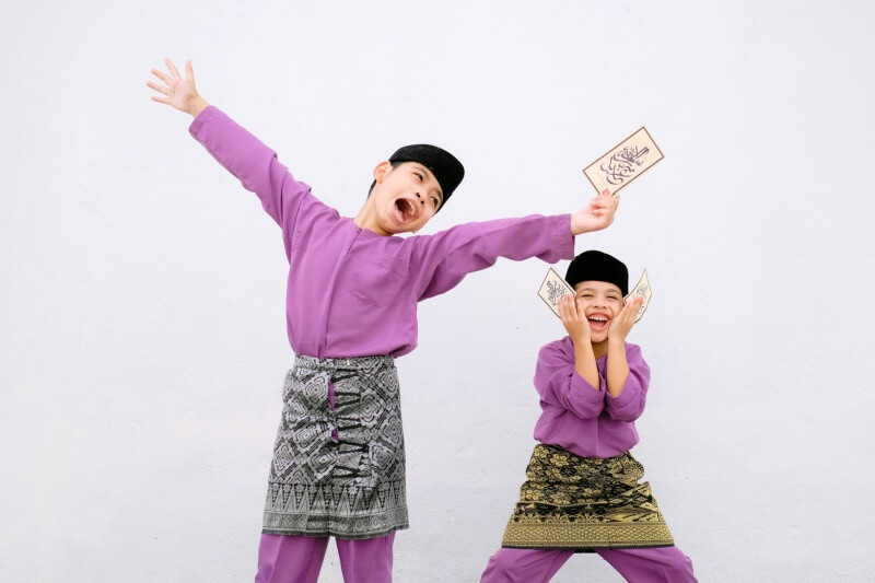 children wearing purple baju melayu having fun during hari raya