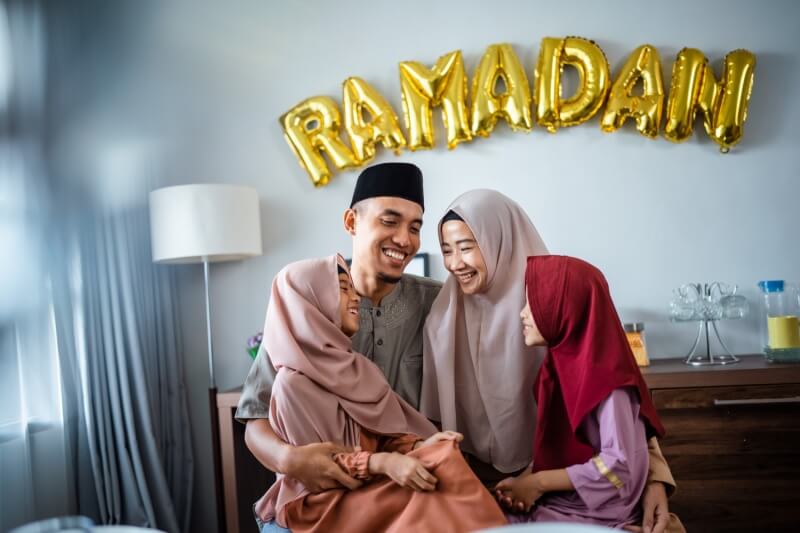 family with a backdrop of ramadan balloons