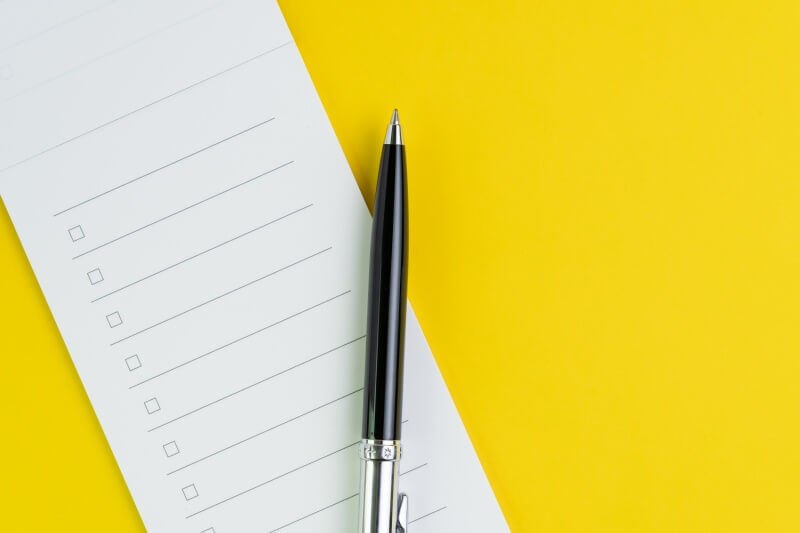 checklist with pen on an isolated yellow background