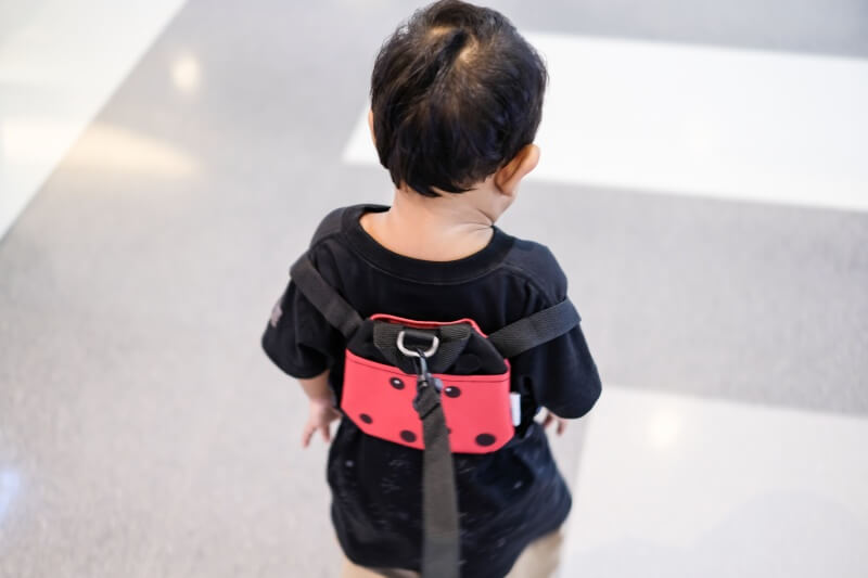 kid on safety strap in public