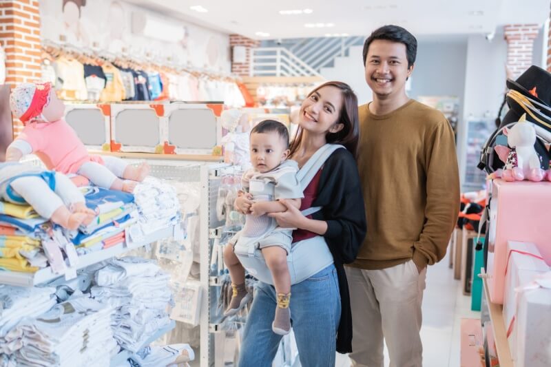 parents with young baby shopping in baby carrier