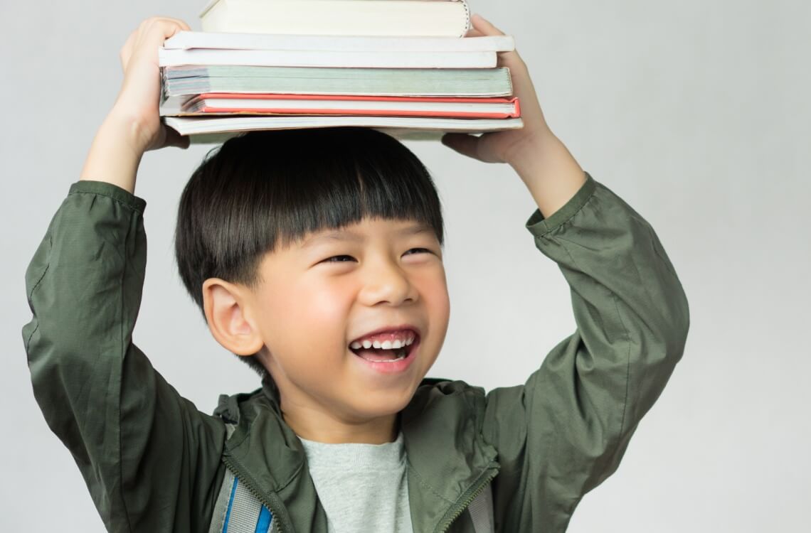 young boy holding books