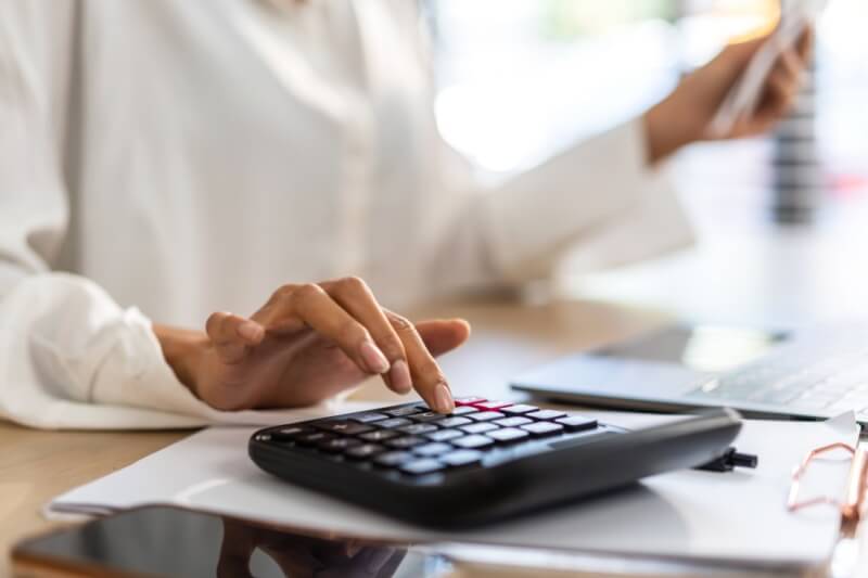 image of person using calculator while counting bill payment