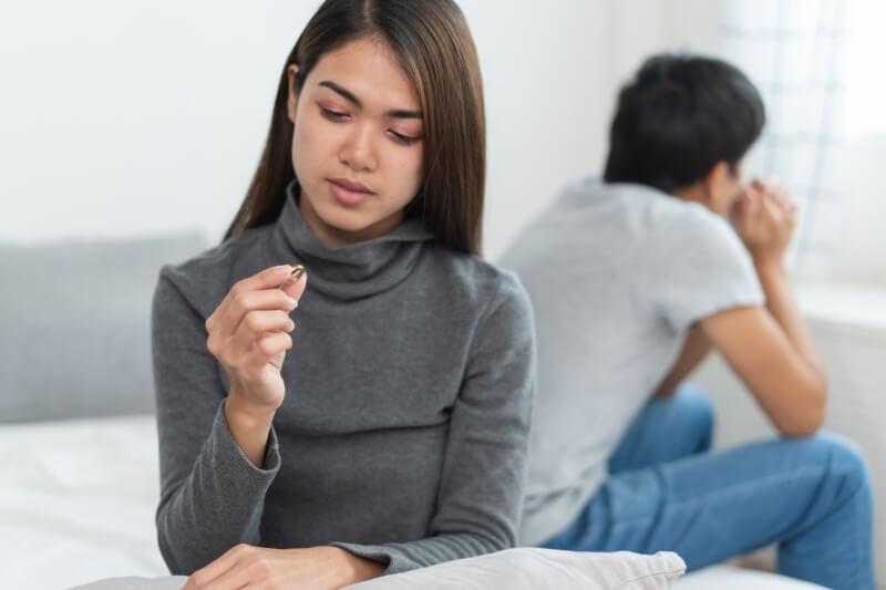 woman arguing with husband looking at wedding ring