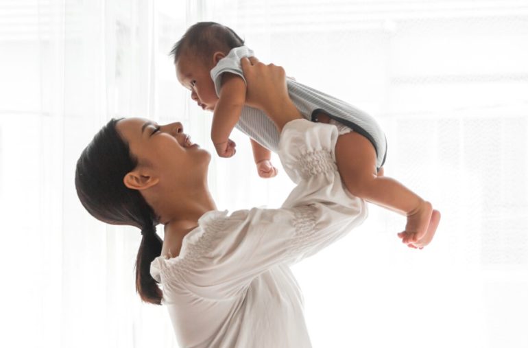 Portrait of enjoy happy love family asian mother playing with adorable little asian baby.