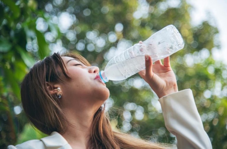 woman drinking water from water bottle