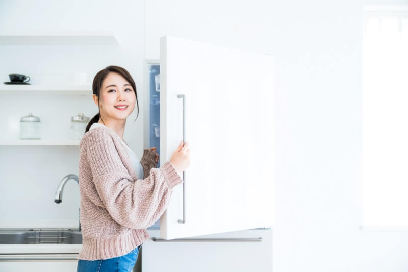 woman at the fridge looking for ingredients