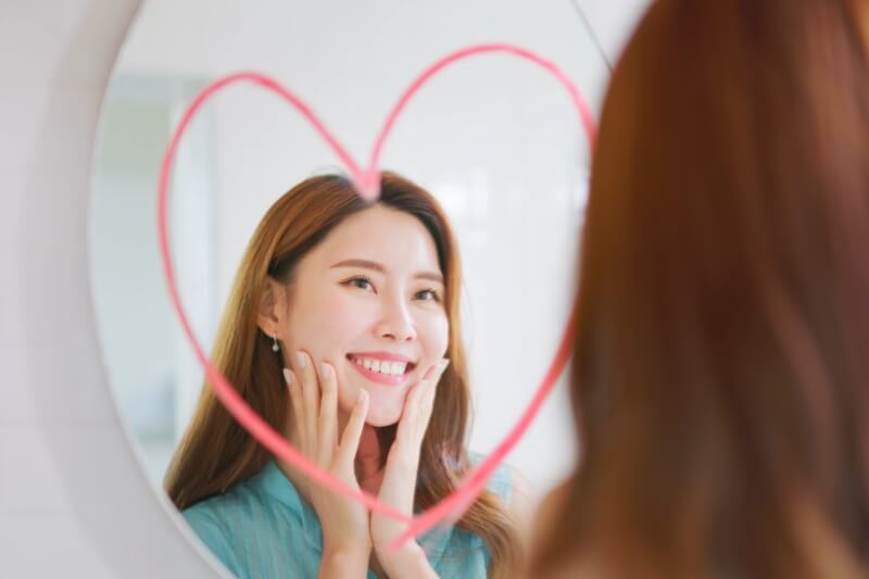 woman smiling in front of the mirror