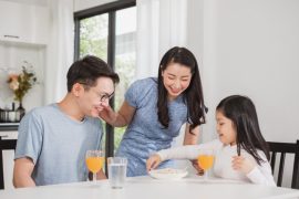 family happy enjoy having breakfast on table in kitchen