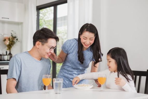 family happy enjoy having breakfast on table in kitchen
