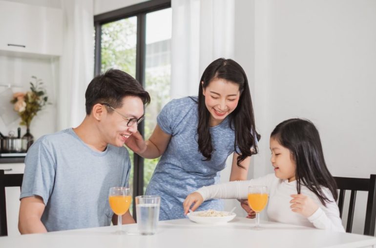 family happy enjoy having breakfast on table in kitchen