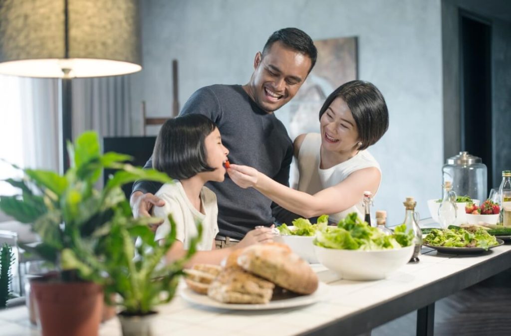 asian family having dinner at the kitchen counter enjoying healthy meals