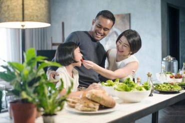 asian family having dinner at the kitchen counter enjoying healthy meals