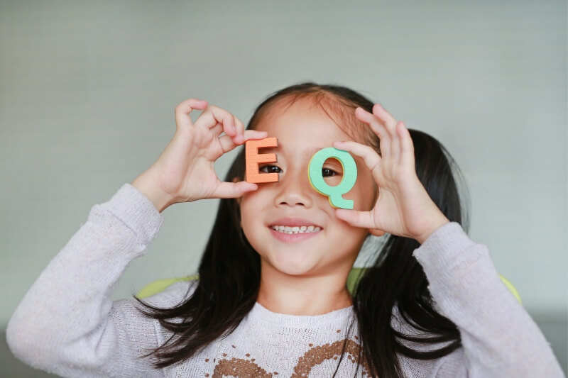 girl holding eq letters 