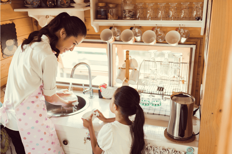mum and daughter washing dishes in the kitchen