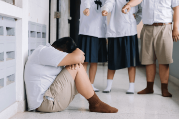 student bullying victim by classmates crying sadly being bullied