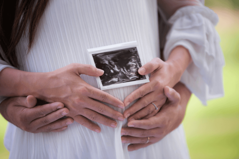 Pregnant woman holding x-ray flim for show her baby