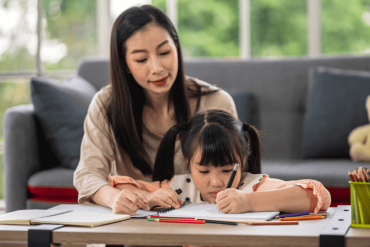 mum teaching daughter studies practicing homeschool