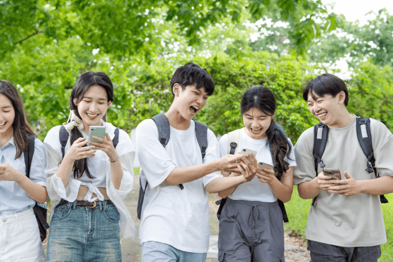 eenagers having fun while using mobile phone
