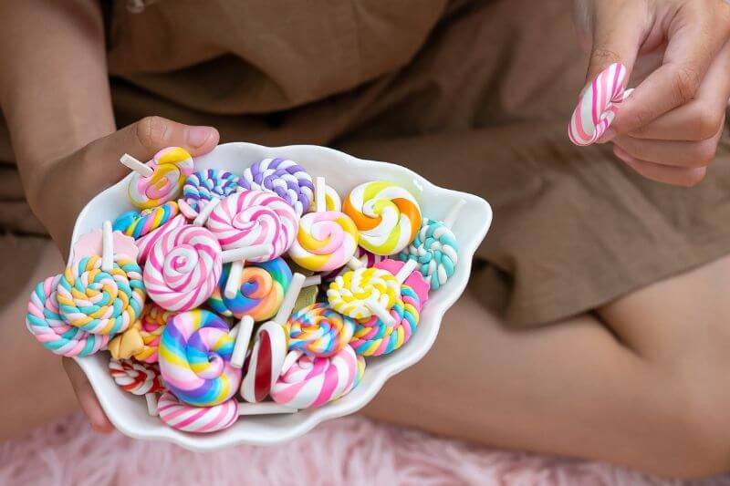 a plate held by a child filled with candy showcasing sugar addiction