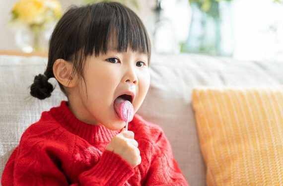 Asian child licking a lollipop
