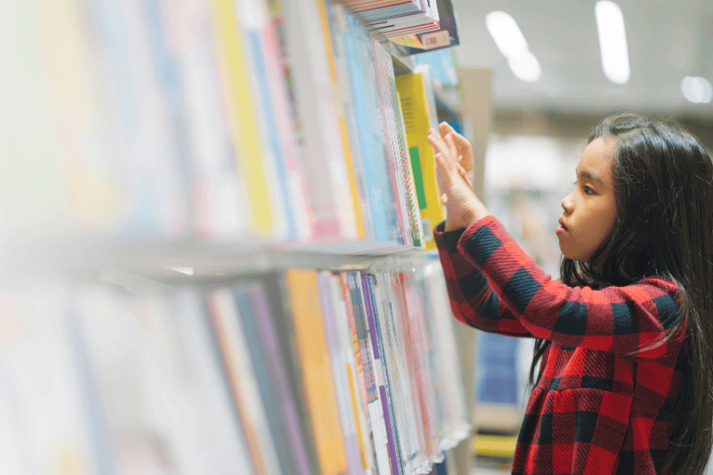 child picking books from the bookshelf 