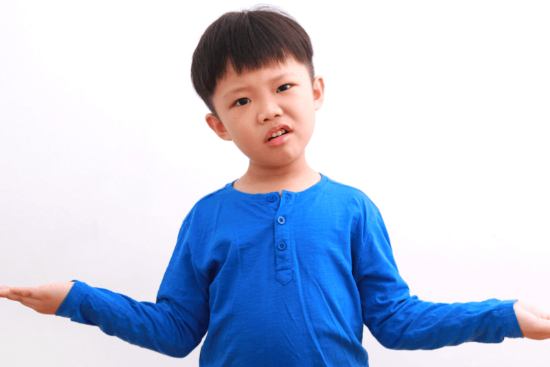 Cute little asian boy confused or doubting expression with his both palm facing up